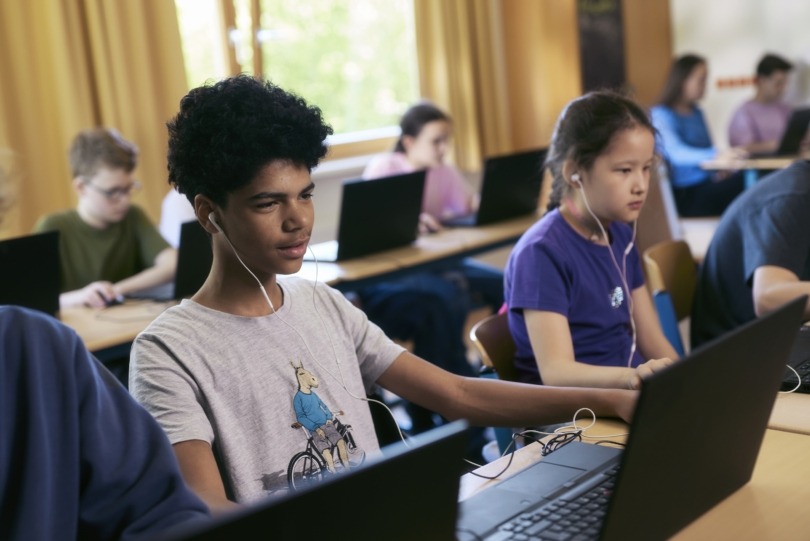 Schulklasse sitzt vor Computern und programmiert bei der Hacker School